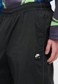 Μαύρα σορτς Nike Air με ελαστική μέση και ραμμένη ετικέτα. Το ύφασμα είναι ελαφρύ και διακριτικά υφασμένο, με αντίθετη ραφή.