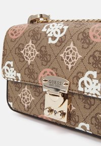 Brązowa torebka w wzory z złotymi elementami. Posiada białe i różowe logo, zapięcie na klapkę oraz teksturowaną powierzchnię materiału.