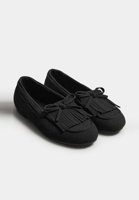 Schwarze Wildlederschuhe mit runder Zehenform, ausgestattet mit einem fransigen Akzent an der Vorderseite und einer Schleifendetail. Glatte Textur und praktische Slipper-Design.