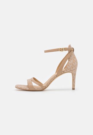 Sandale beige à talon haut avec bride à la cheville et boucle dorée, avec talon et semelle en tissu à motif.