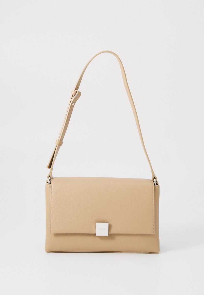 Borsa in pelle beige con texture liscia, forma rettangolare, chiusura a scatto e tracolla regolabile, caratterizzata da un piccolo accento metallico.