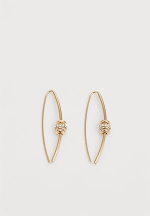 Boucles d’oreilles chaîne fines en ton or avec une bande centrale de petits cristaux clairs sur un cadre en fil courbé minimaliste.