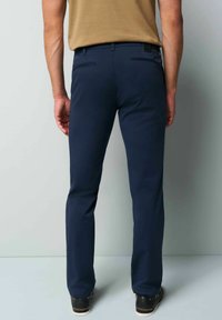 Navy blue straight-cut trousers made of smooth cotton blend, featuring two back pockets and a subtle brand tag on the waistband.