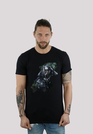 Black cotton t-shirt featuring a graphic print of a character in a mask and armor, set against a green background. Short sleeves, crew neck.
