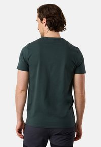 Mörkgrön bomullströja med rund hals och korta ärmar, med en mjuk yta och minimal sömdetaljering.