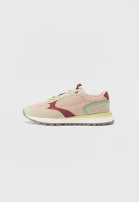 Light pink and beige sneaker with red and green accents, mesh fabric, padded collar, and a textured rubber sole. Features flat laces.