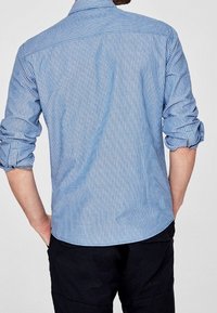 Blauw-wit gestreept overhemd met lange mouwen en opgerolde cuffs, rugpasdetails en een gebogen zoom. Katoenen stof met een zachte textuur.