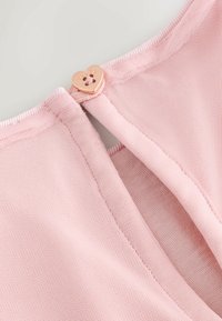 Rosa strukturiertes Stoff mit einer herzförmigen Metallknopfverschluss. Der Stoff verfügt über ein feines Netzdesign und abgesteppten Kanten.