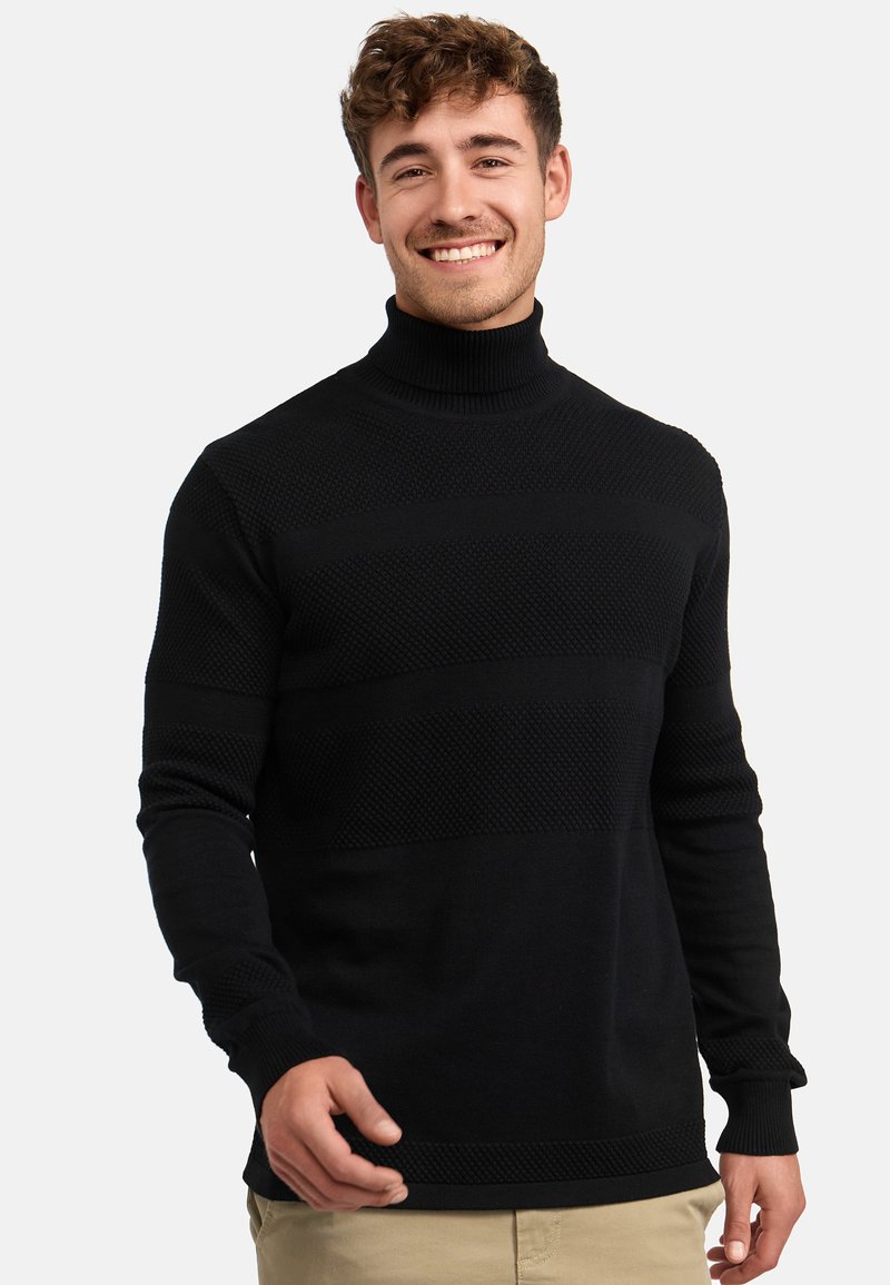 Maglione a collo alto nero con motivi texture, polsini e orlo a coste. Materiale in maglia morbida, forma aderente, con maniche lunghe e colore uniforme.