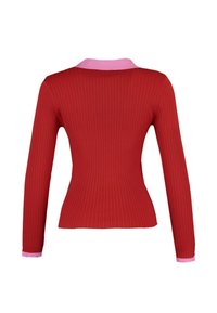 Rotes, geripptes Langarmoberteil mit taillierter Silhouette, ausgestattet mit einem rosa Kragen und Manschetten. Das Material wirkt glatt mit einer vertikalen Textur.