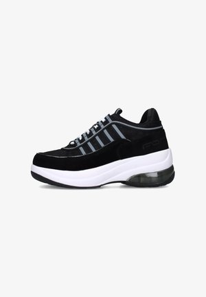 Sneaker in suede e mesh neri con una suola intermedia bianca, caratterizzata da accenti grigi e un'unità di ammortizzazione trasparente nel tallone.