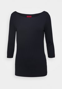 Schwarzes, geripptes Langarmoberteil mit einem Bootsausschnitt und tailliertem Schnitt, das auf dem inneren Etikett am Hals und am Ärmelbündchen ein kleines rotes Logo aufweist.