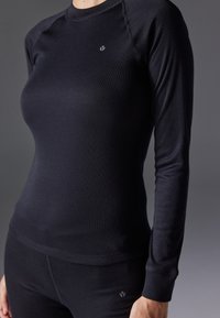 T-shirt thermique noir à manches longues avec un design ajusté et une texture côtelée. Présente un petit logo sur la poitrine et des poignets assortis.