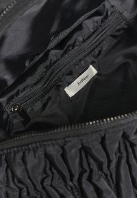 Sort stofpose indvendigt med en lynlåslomme og en hvid etiket med mærkenavnet "InWear."