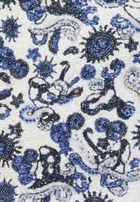 Tkani s perlicama koja sadrži složene plave i bijele spiralne uzorke s raznolikim teksturama, sjajnim naglascima i reflektirajućim detaljima.