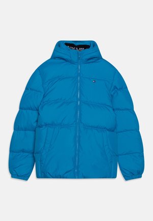 Veste d'hiver matelassée bleue avec capuche, fermeture éclair à l'avant et poches latérales, avec un petit logo rectangulaire sur la poitrine.