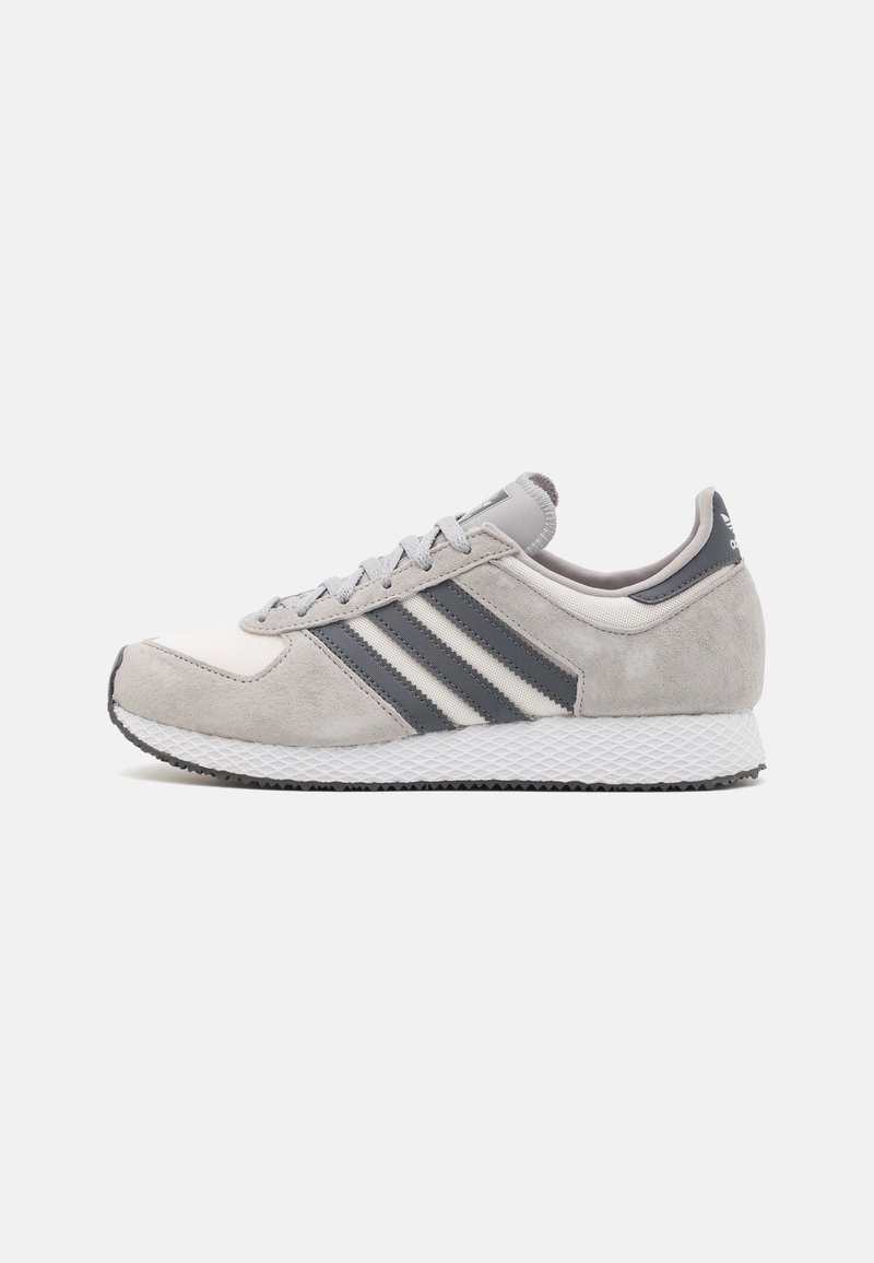 Gray and white Adidas sneaker with black three stripes, mesh and suede upper, white textured sole, and lace-up closure, shown from the side.