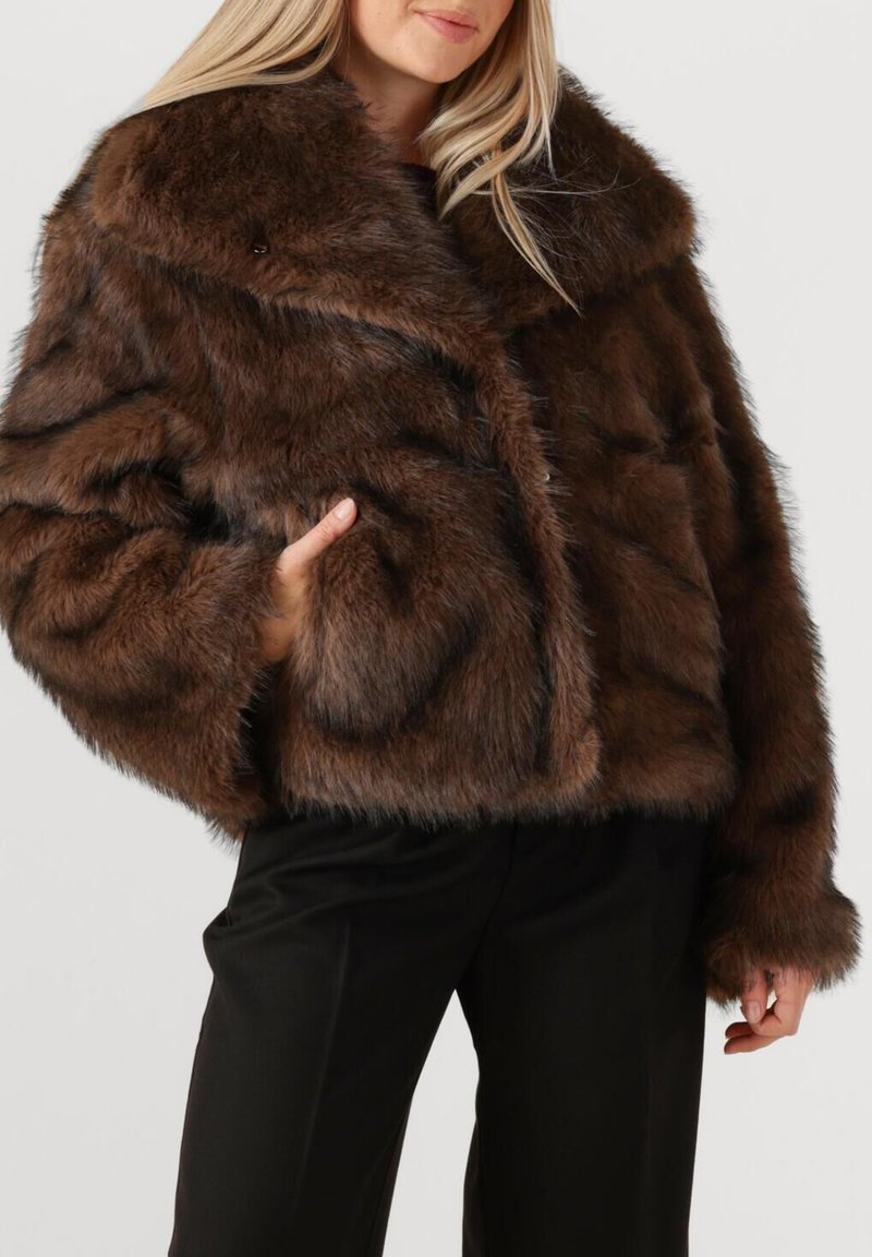 Bruine nepbont cropped jas met een brede kraag, voorzien van een harige textuur en een relaxte pasvorm. Zakdetail aan de linkerkant.