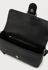 Czarna skórzana torebka o gładkiej fakturze, prostokątnym kształcie, zapięciu na srebrny zatrzask oraz wewnętrznej kieszeni na zamek. Widoczna podszewka wewnętrzna.