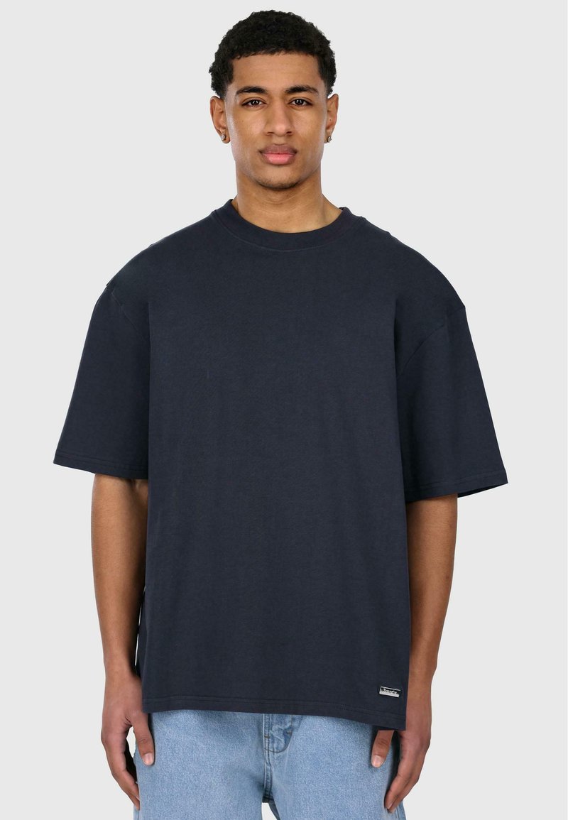 Granatowa, oversize t-shirt wykonana z bawełny, z krótkimi rękawami i okrągłym dekoltem. Posiada małą metkę z logo na dole.