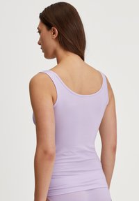 Light purple tank top, made of soft fabric, featuring a scoop neckline and thin straps, fitted design, smooth texture.
