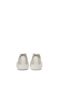 Sneakers beige con accenti a strisce bianche, materiale in pelle liscia, punta rotonda e suola in gomma testurizzata con logo impresso sul tallone.
