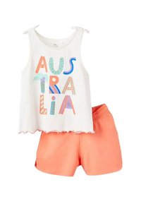 Top bianco senza maniche con una vivace scritta "AUSTRALIA" e pantaloni corti corallo con vita elastica. I materiali sembrano leggeri e traspiranti.