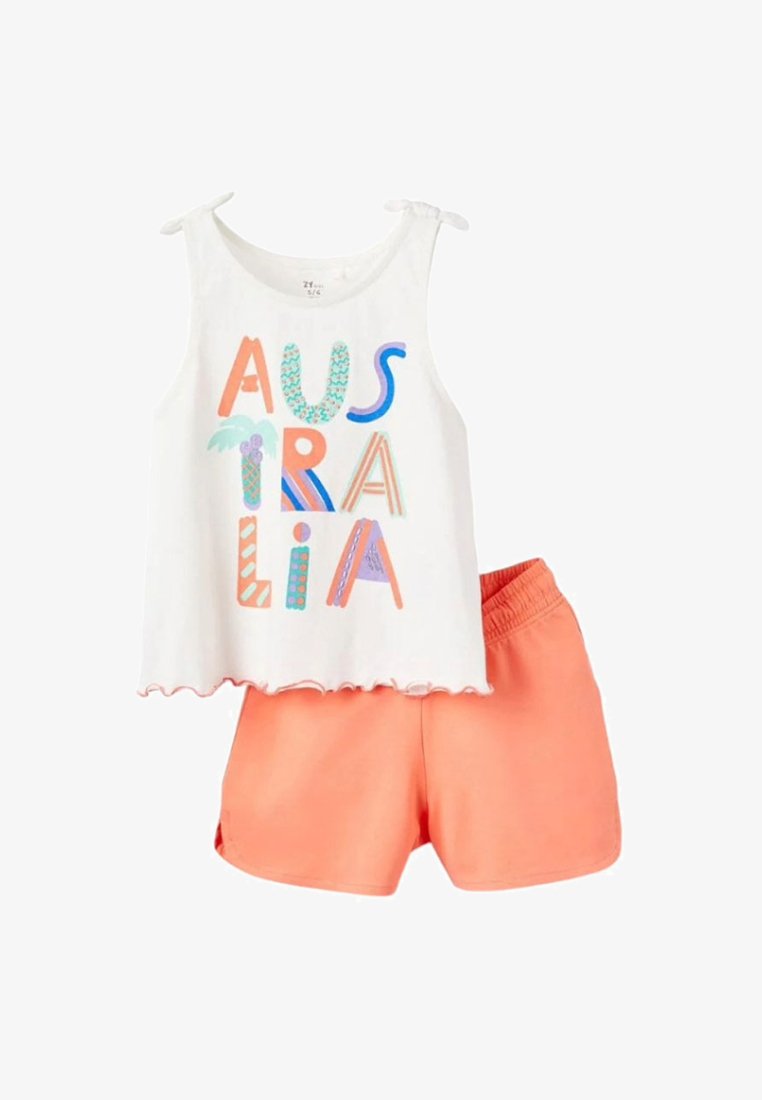 Top bianco senza maniche con una vivace scritta "AUSTRALIA" e pantaloni corti corallo con vita elastica. I materiali sembrano leggeri e traspiranti.