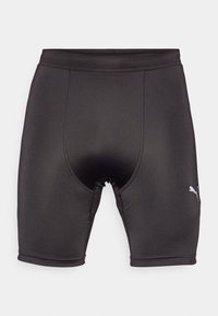 Pantalones cortos deportivos negros hechos de tela elástica, con un diseño ajustado, textura suave y un pequeño logo gris en el lateral.