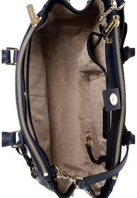 Interno di una borsa a tracolla blu navy con accessori dorati, caratterizzato da una fodera liscia di un beige chiaro con un sottile motivo circolare e numerose tasche.