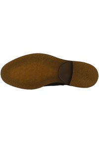 Suela de zapato negra con una superficie texturizada, que presenta un tacón marrón ligeramente elevado y una punta suave y redondeada.