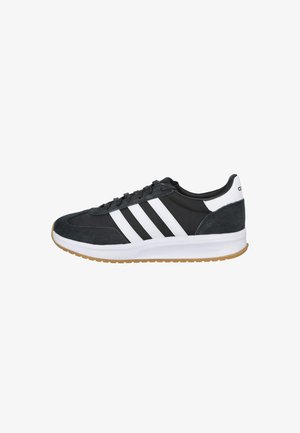 Zapatilla Adidas en blanco y negro con tres franjas blancas, diseño con cordones, suela blanca acolchada y suela exterior de color goma, vista de lado.
