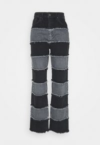 Svart och grå patchwork-jeans i denim med hög midja, med fransade kanter och en utsvängd bendesign.