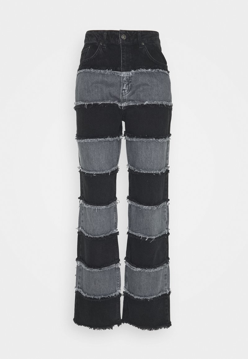 Svart och grå patchwork-jeans i denim med hög midja, med fransade kanter och en utsvängd bendesign.
