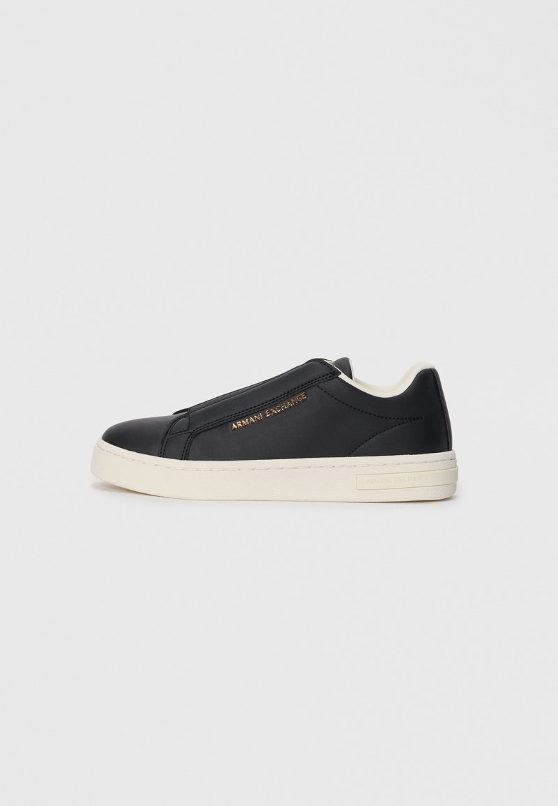 Sneaker slip-on in pelle nera con suola bianca, logo dorato "Armani Exchange" sul lato e dettaglio di cucitura minimalista.