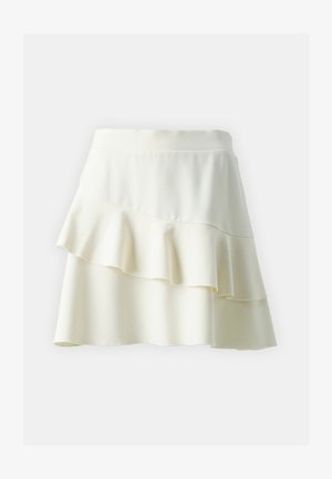 Balta plačiai išsiplėtusi sijonas su sluoksniuotais nėriniais, lygiu paviršiumi ir plačiu juosmeniu. Trumpas ilgis su laisvu prigludimu.