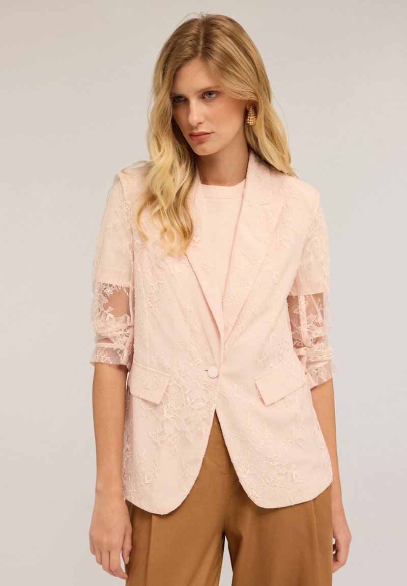 Hellrosa Blazer mit floralem Spitzenüberzug, strukturierte Form, Reverskragen, Knopfverschluss und transparente, gestickte Ärmel. Taillierte Passform.
