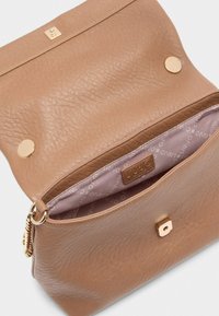 Borsa a tracolla in pelle con texture color marrone chiaro, chiusura a patta, hardware dorato e fodera interna con motivo rosa. Dettaglio con zip sul lato.
