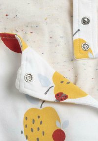 Camisa de manga corta de algodón blanco con motas multicolores; presenta un estampado de frutas amarillas y mariquitas, con cierre a presión plateado en el cuello.