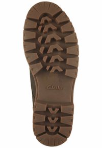 Braune Gummi-Außensohle mit einem robusten Profil. Mit "Clarks" nahe der Ferse markiert. Entwickelt für Traktion und Langlebigkeit.