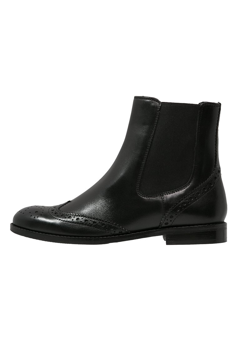 Botín negro de cuero hasta el tobillo con detalles de brogue, paneles laterales elásticos y un bajo tacón apilado. Textura suave y diseño estilizado.