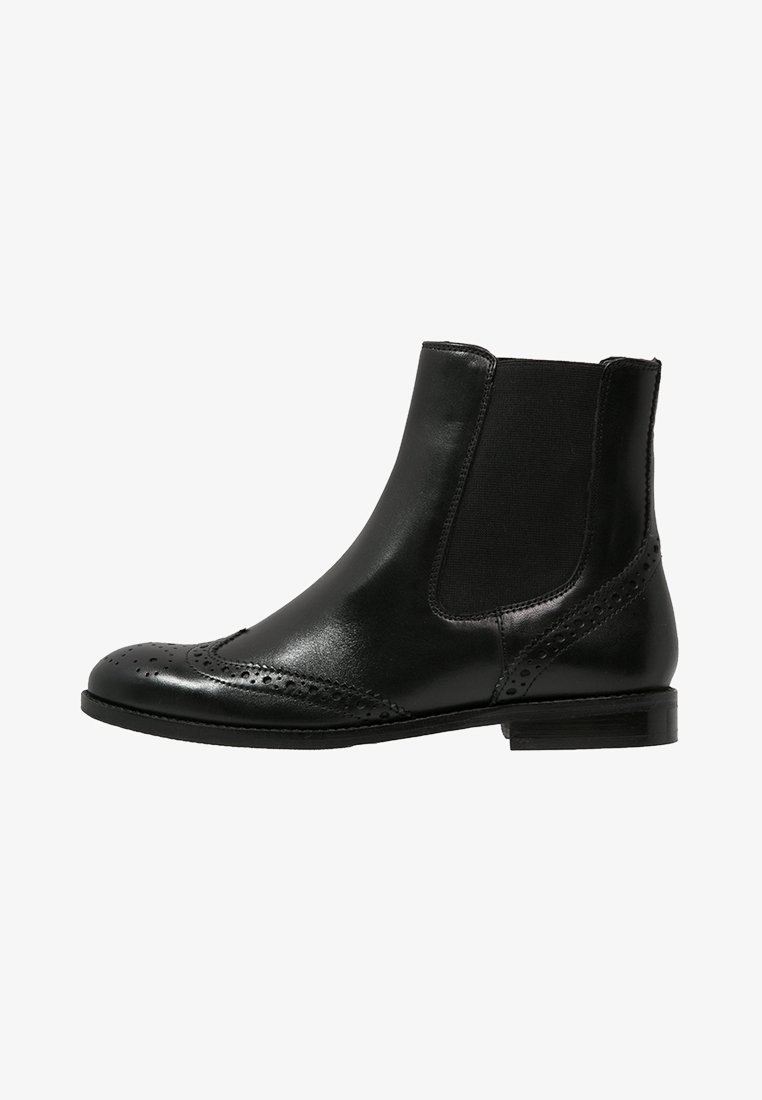 Botín negro de cuero hasta el tobillo con detalles de brogue, paneles laterales elásticos y un bajo tacón apilado. Textura suave y diseño estilizado.