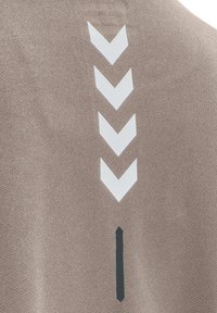 Brun sportig tyg med vita chevronmönster och en vertikal svart linje. Sles ytstruktur, åtsittande design, lämplig för sportkläder.