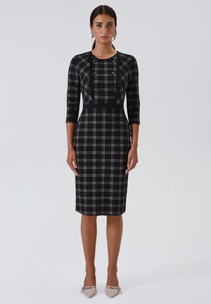 Black plaid dress featuring a fitted silhouette, three-quarter sleeves, and decorative buttons along the front; paired with light-colored pointed heels.