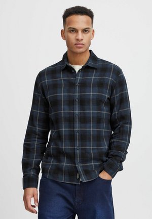 Camisa de cuadros negra y azul marino de botones, en una suave mezcla de algodón, con cuello y mangas largas, dobladillo recto y detalles de costura sutiles.