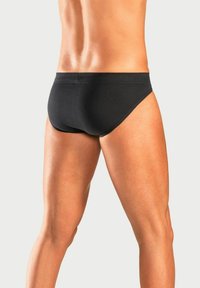Schwarze Herrenunterhosen aus weichem, dehnbarem Material, mit einem tief sitzenden Design und nahtlosen Kanten für Komfort und eine enganliegende Passform.