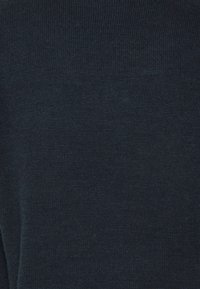 Ciemnoniebieski sweter na drutach o delikatnej teksturze, z prążkowanym wzorem i okrągłym dekoltem. Tkanina wydaje się miękka i ma subtelny połysk.