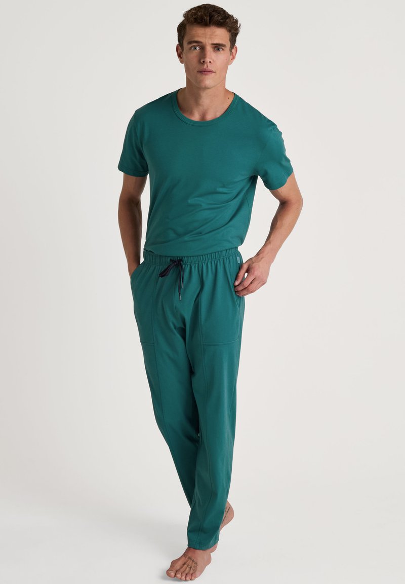 Teal T-shirt met korte mouwen en een ronde hals, gecombineerd met bijpassende joggerpants met een elastische tailleband en zijzakken.