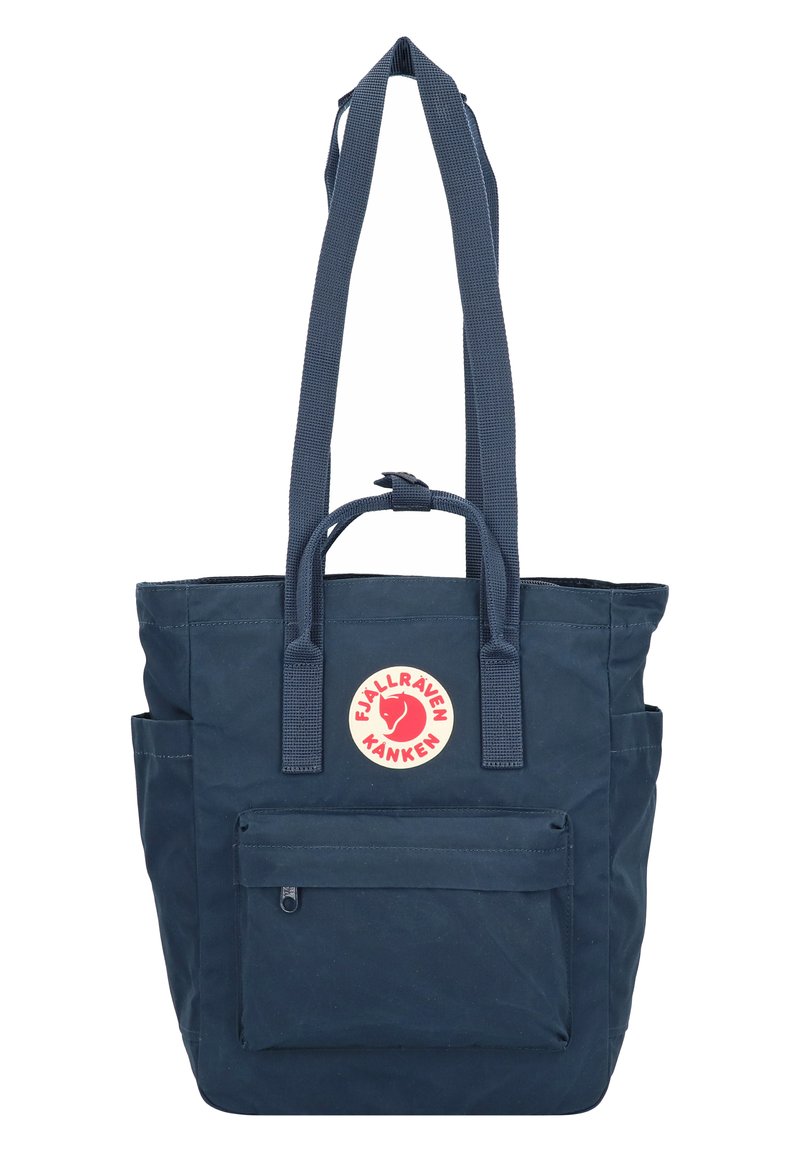 Borsa tote blu navy con due manici lunghi, una tasca frontale con zip e una toppa rotonda con logo. Realizzata in tessuto resistente con finitura testurizzata.