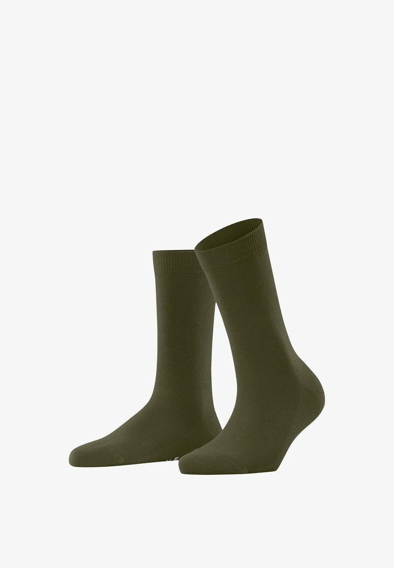 Une paire de chaussettes de crew unies de couleur vert olive foncé se tenant debout sur un fond blanc.
